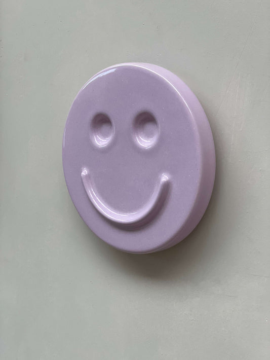 Orchid 'HAPPY' ceramic artwork with smiley face design on light purple background.