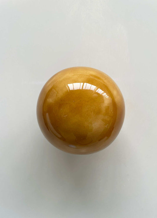 Handcrafted ceramic ball in cognac color, wall sculpture by Edith Beurskens and April van Domburg.