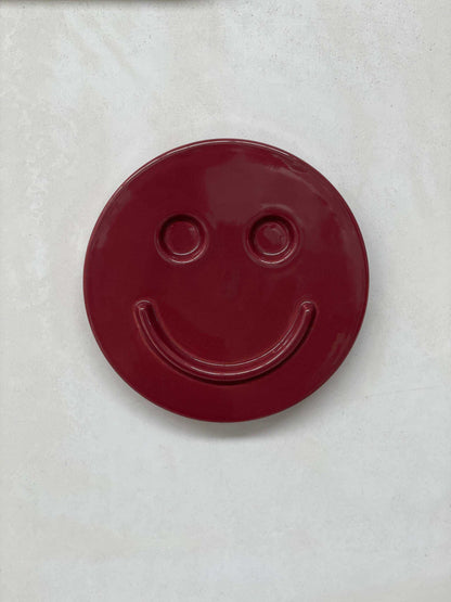 Burgundy ceramic smiley face artwork by Edith Beurskens, handcrafted at Royal Goedewaagen.