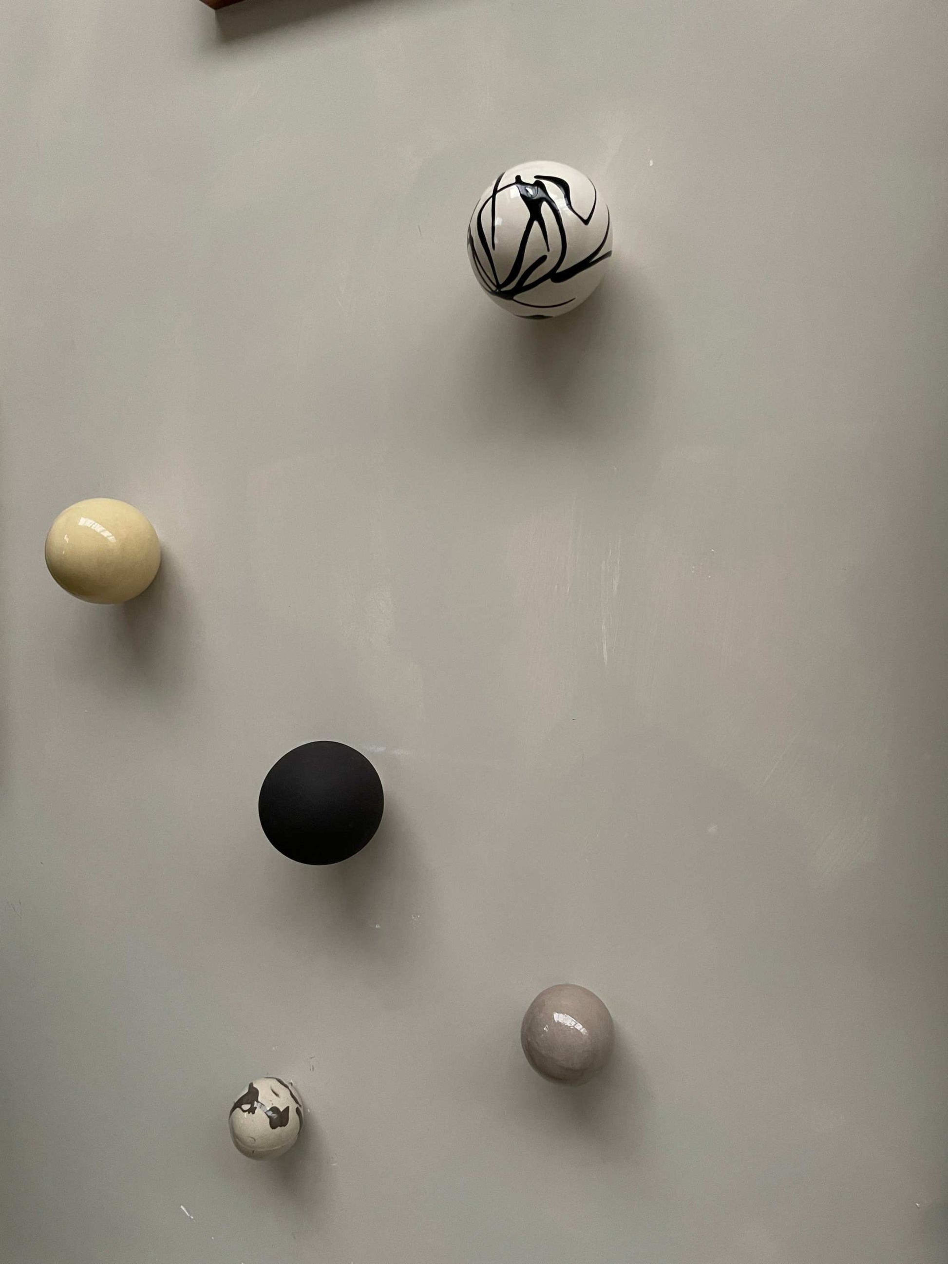 Handcrafted ceramic ball wall sculpture with artsy swirl design.