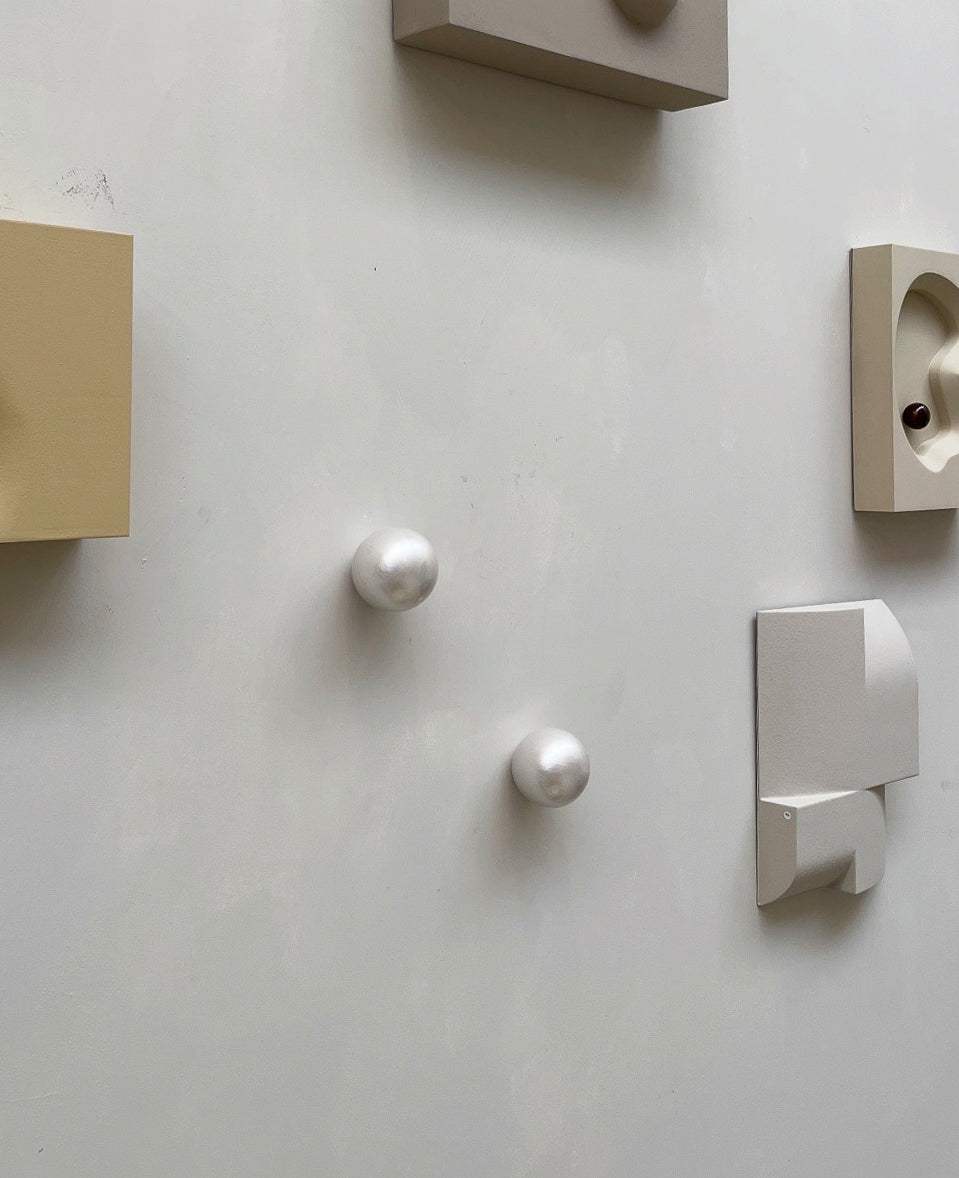 Handcrafted ceramic wall sculpture, Pearl Look, reflecting light and shadow.