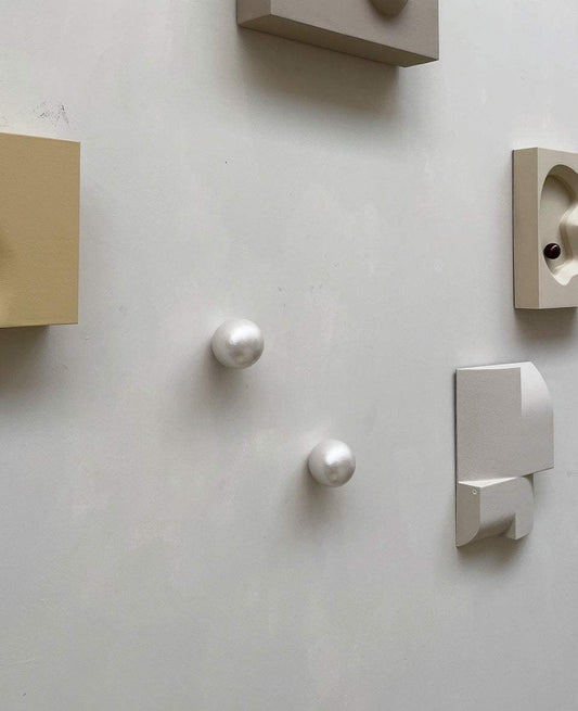 Handcrafted ceramic wall sculpture, Pearl Look, reflecting light and shadow.