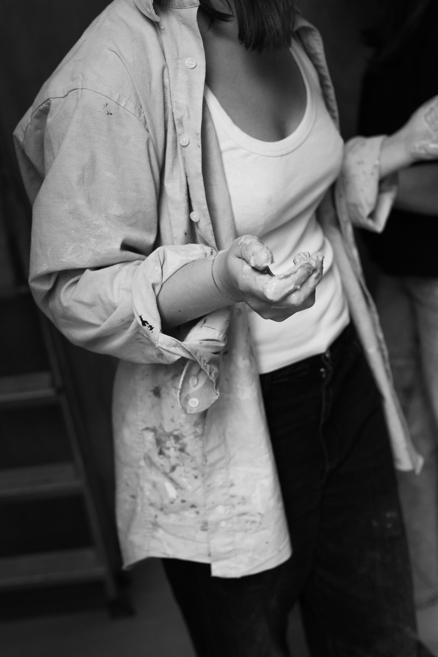 Private throwing wheel lesson participant holding clay in a cozy atelier.