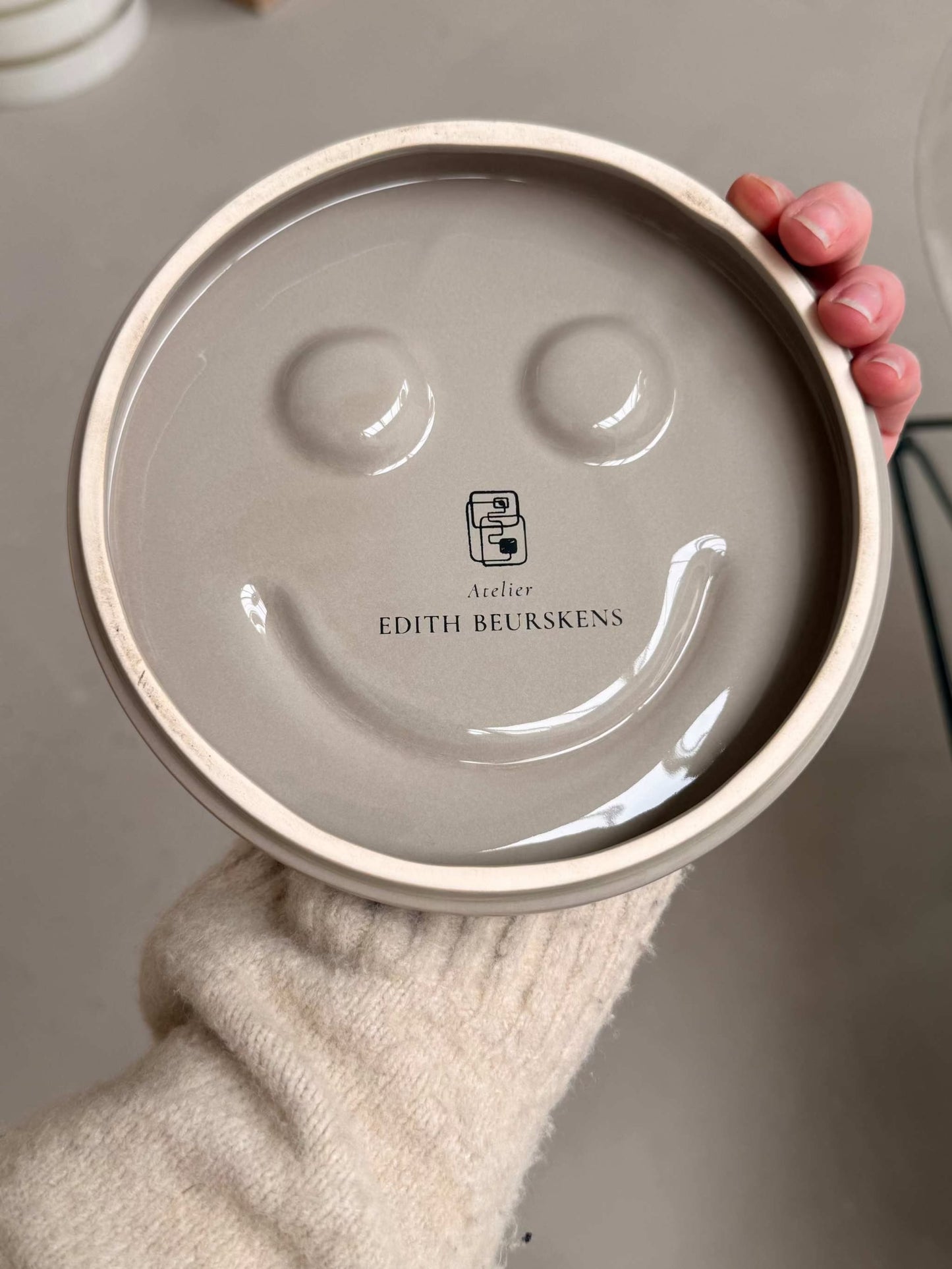 Handcrafted HAPPY ceramic wall art by Edith Beurskens with smiley face design and glazed finish