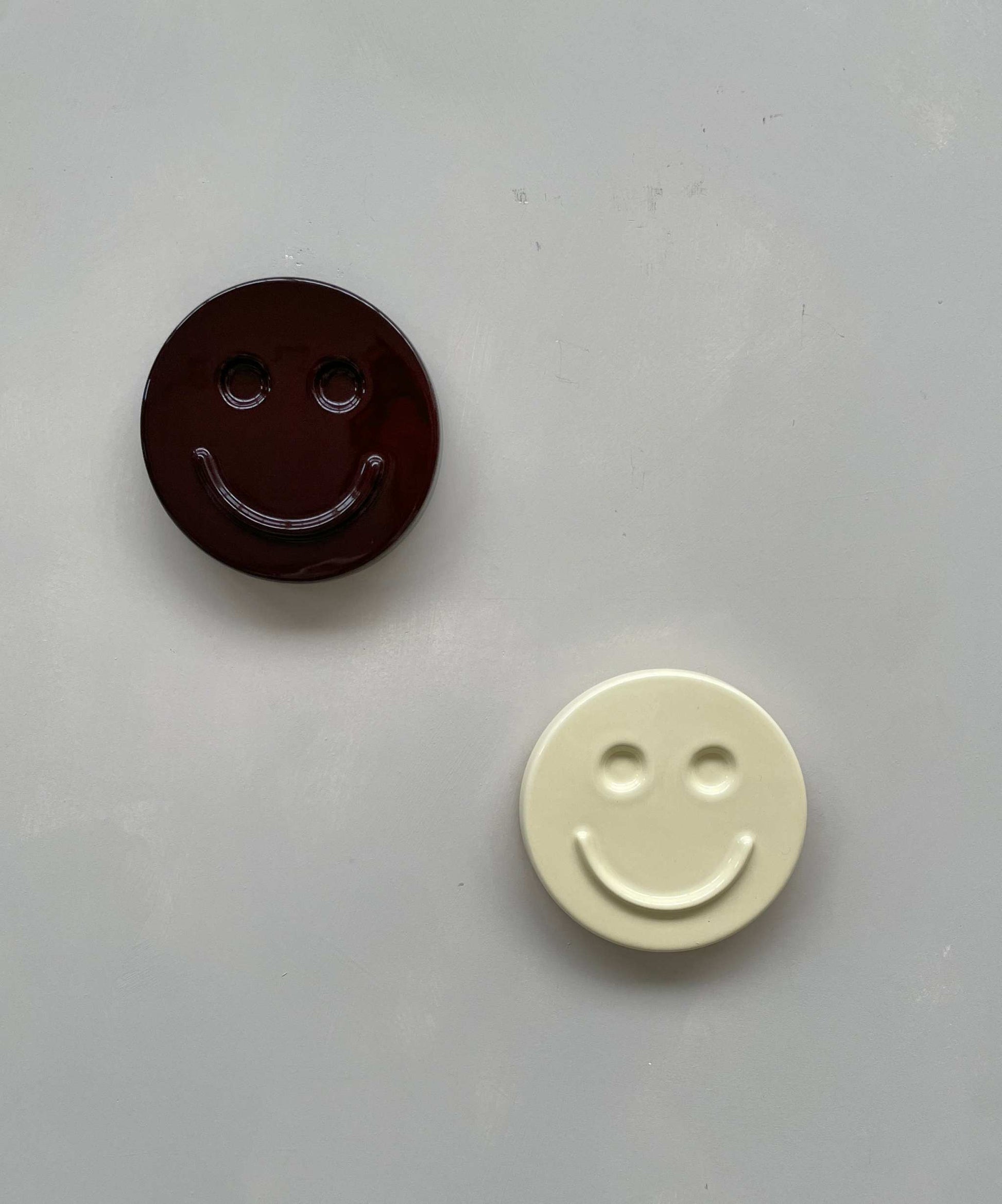 Butter 'HAPPY' ceramic smiley artwork, handcrafted by Edith Beurskens, showing two smiley face designs.