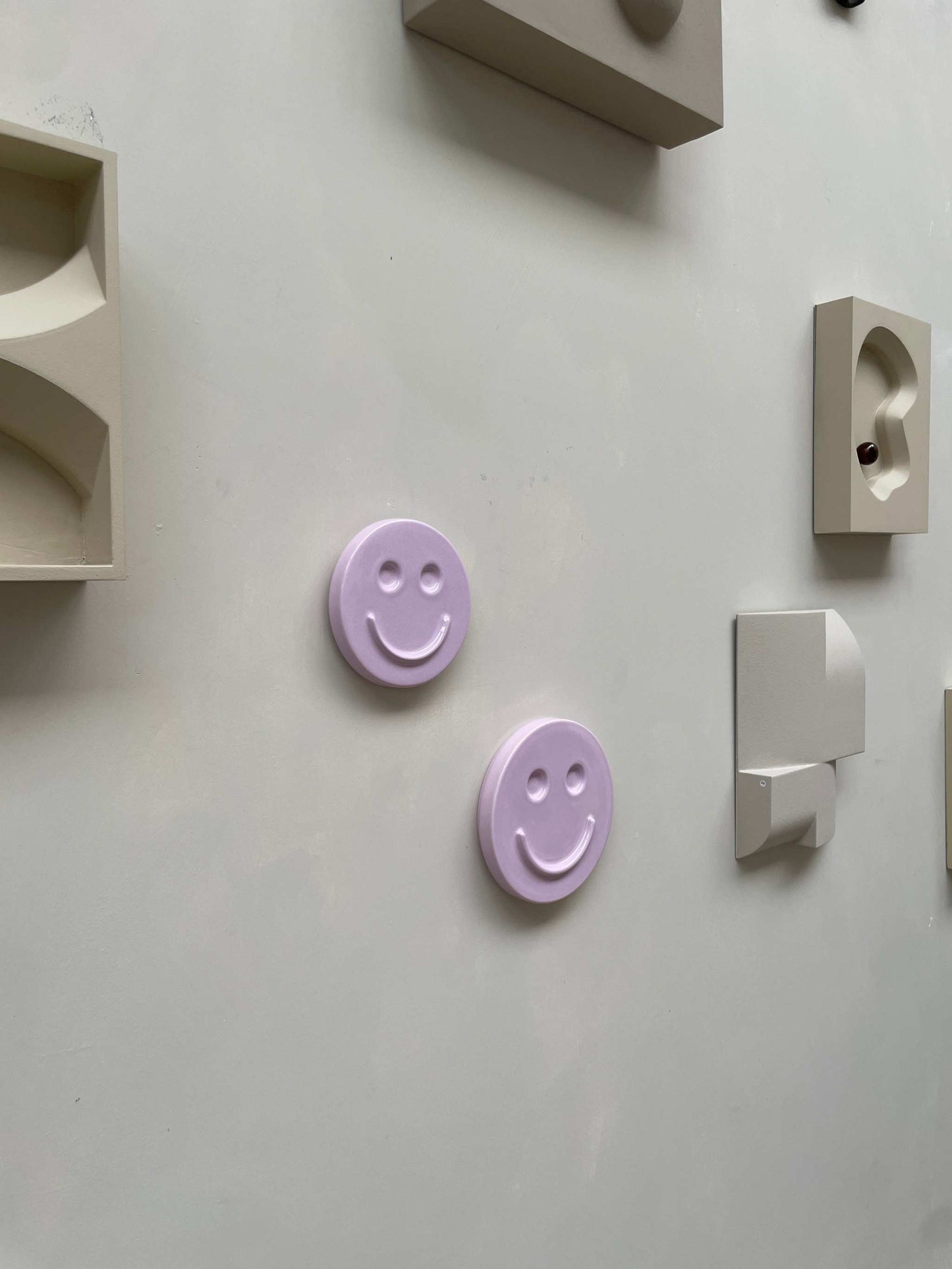 Orchid 'HAPPY' ceramic artwork on display, smiley face design.