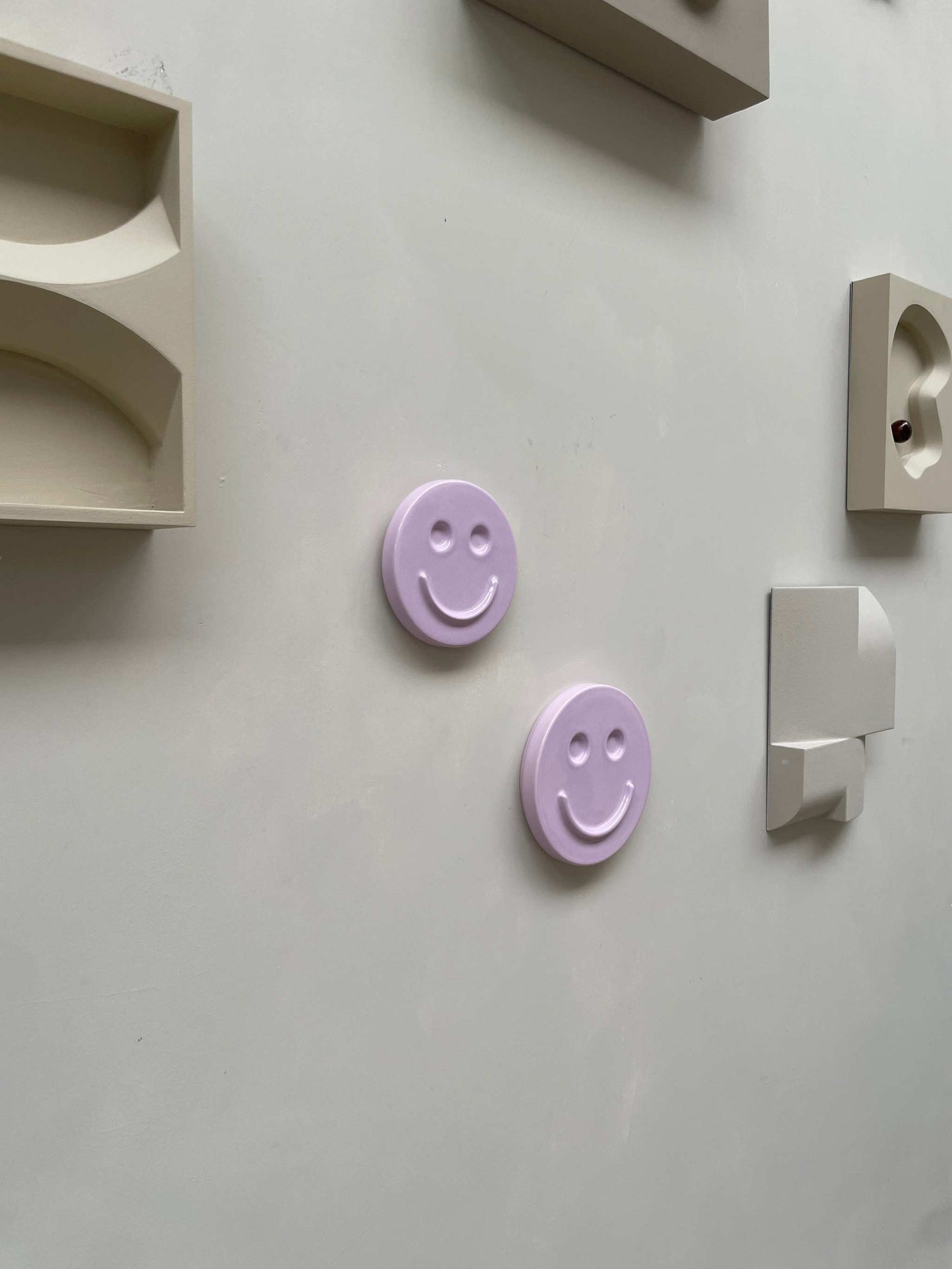 Orchid 'HAPPY' ceramic artwork, handcrafted smiling face designs on display, perfect for kids' rooms or gifts.