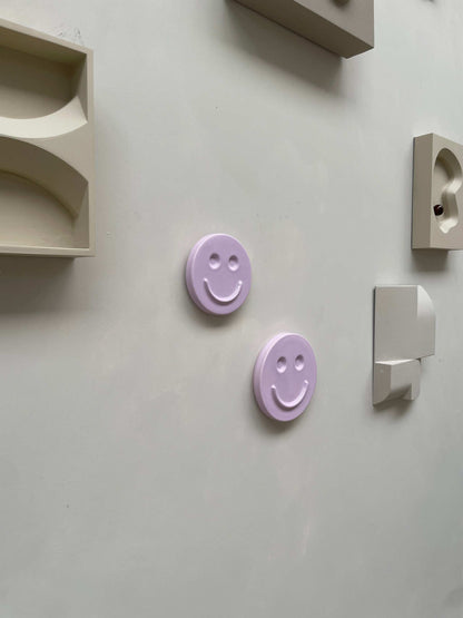 Orchid 'HAPPY' ceramic artwork, handcrafted smiling face designs on display, perfect for kids' rooms or gifts.