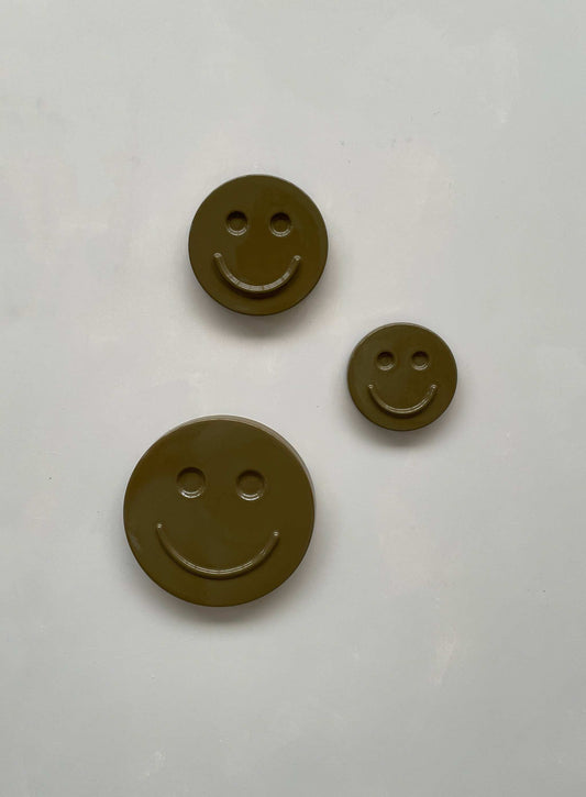 Olive 'HAPPY' ceramic smiley face artwork trio on white background.