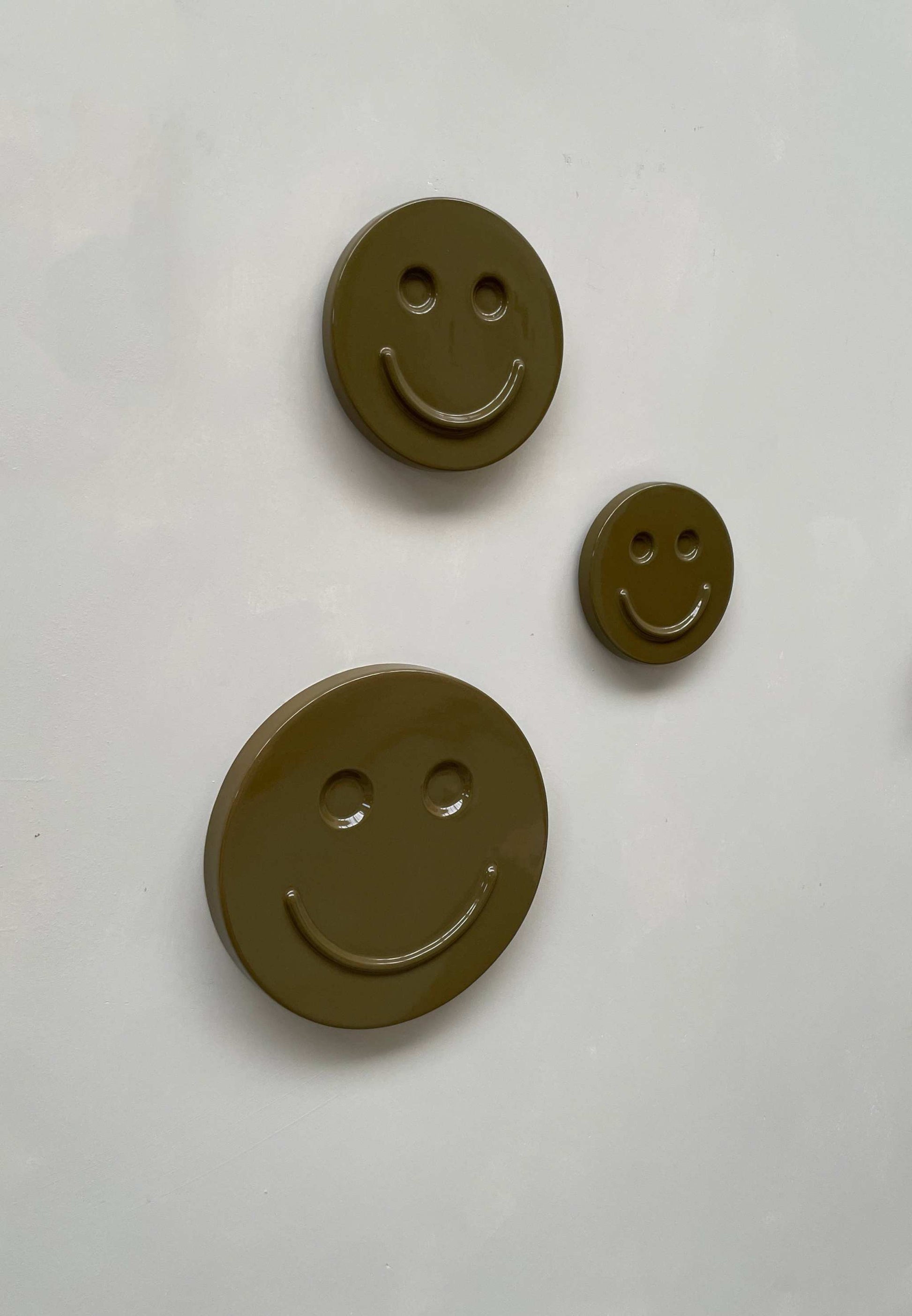 Olive 'HAPPY' ceramic artwork with smiley faces, handcrafted in olive green glaze.