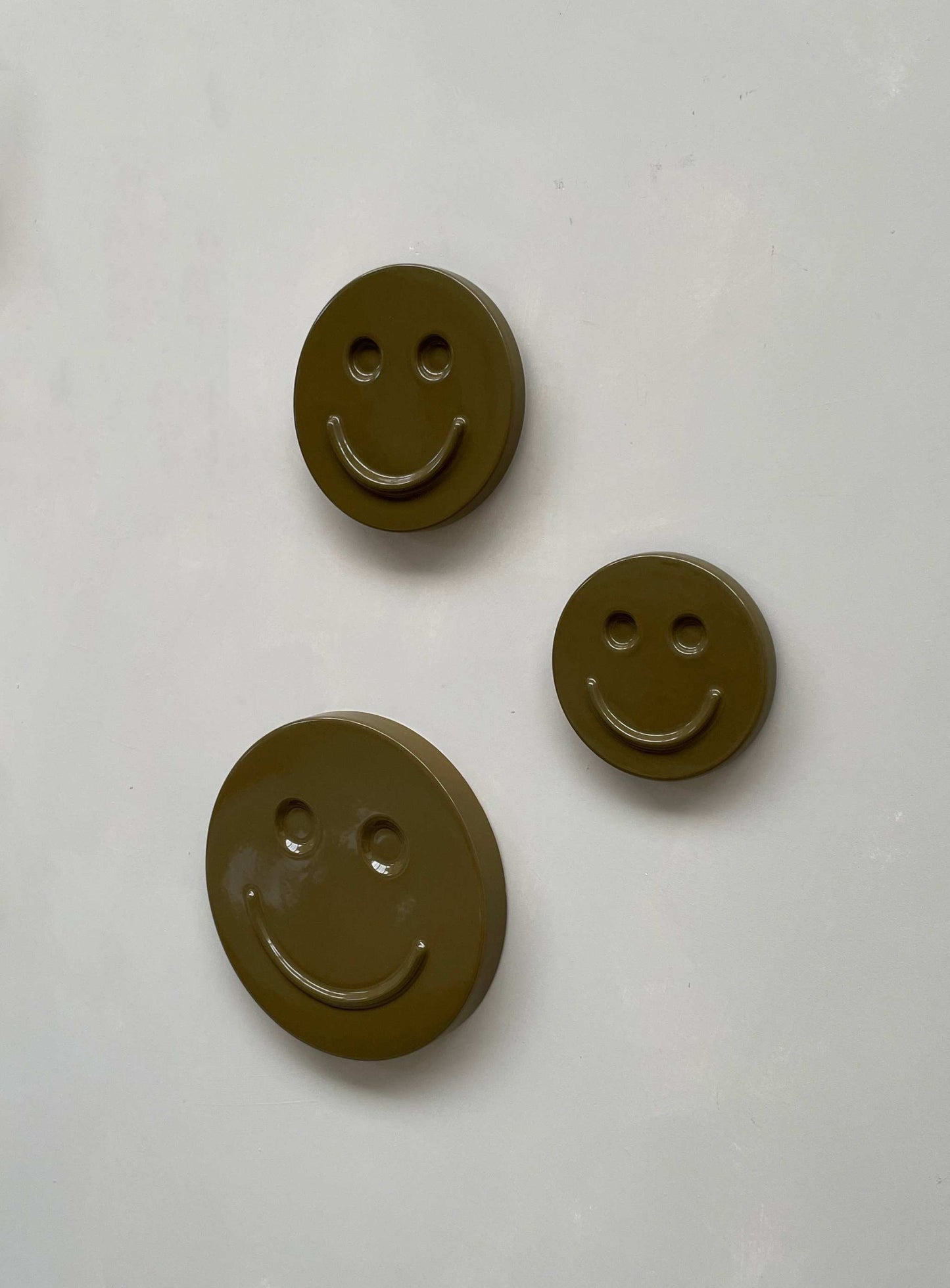Olive 'HAPPY' ceramic artwork featuring smiling faces, handcrafted and glazed.