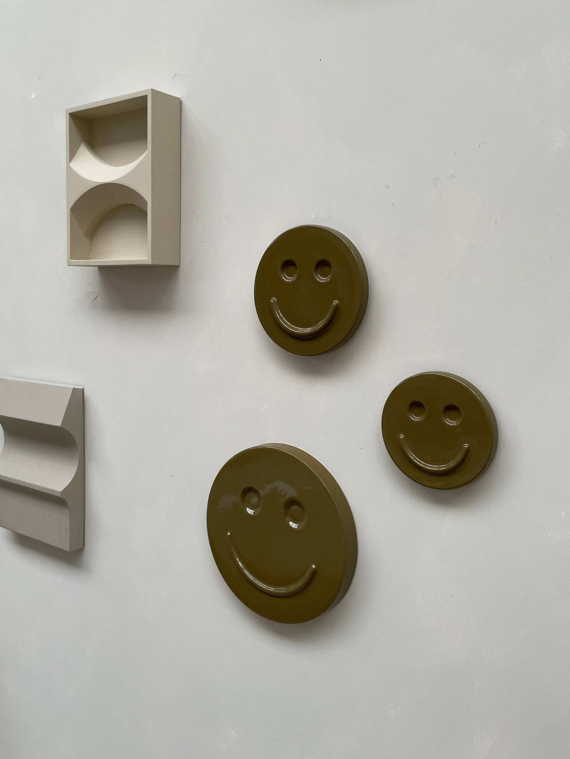 Olive 'HAPPY' ceramic smiley artwork by Edith Beurskens, available in 15, 18, and 25 cm sizes, handcrafted and glazed.