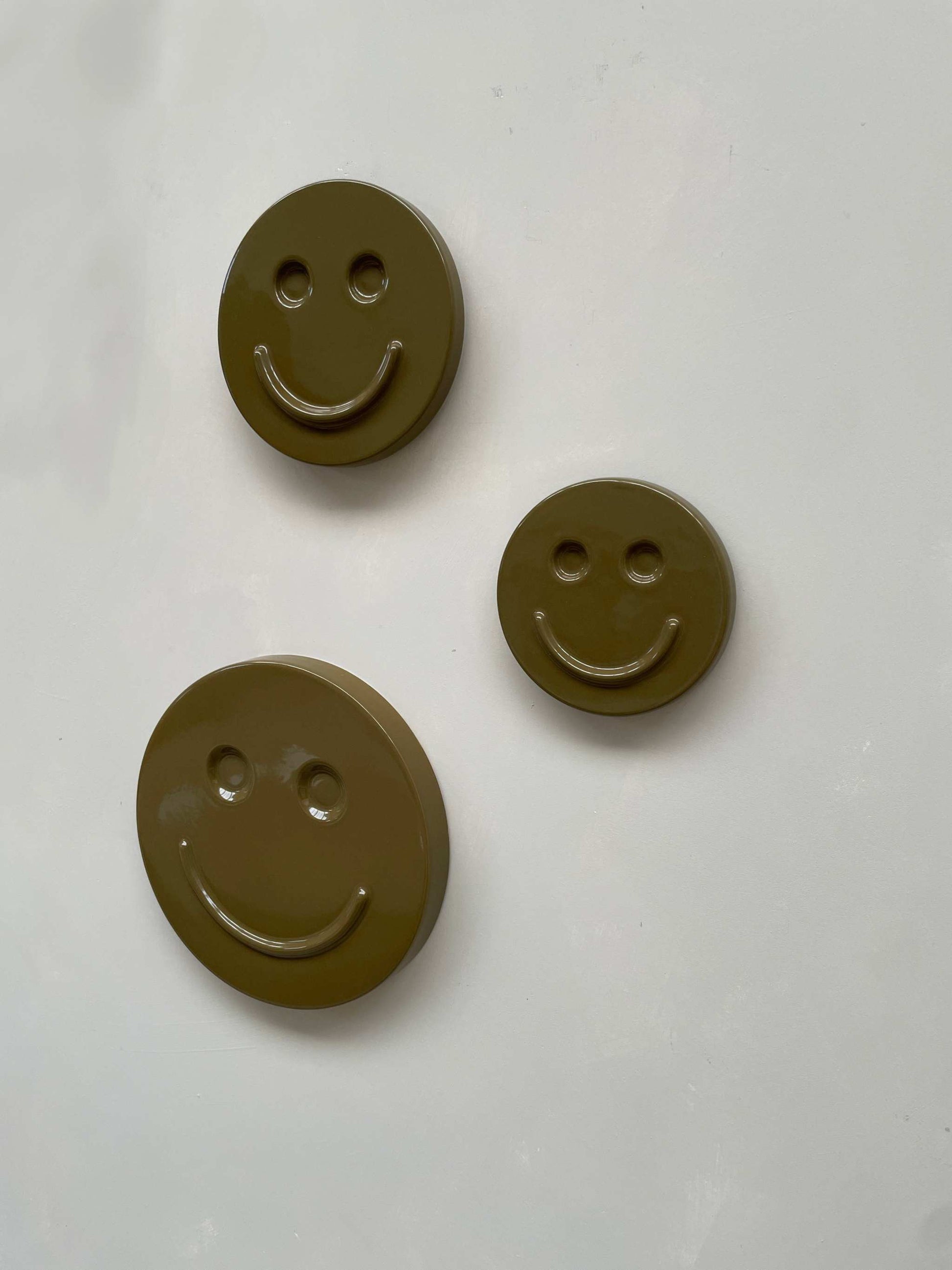 Olive 'HAPPY' ceramic artwork by Edith Beurskens, handcrafted smiley face design.