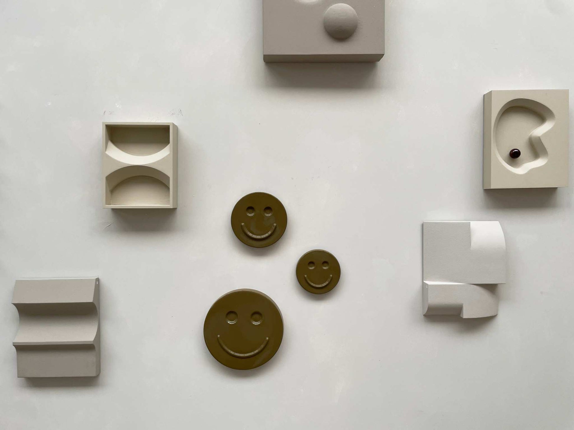 Olive 'HAPPY' ceramic artwork with smiley faces, handcrafted and glazed, by Edith Beurskens.