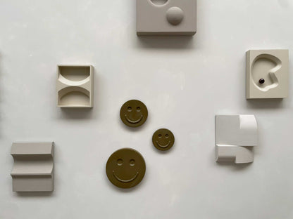 Olive 'HAPPY' ceramic artwork with smiley design, handcrafted by Edith Beurskens at Royal Goedewaagen.