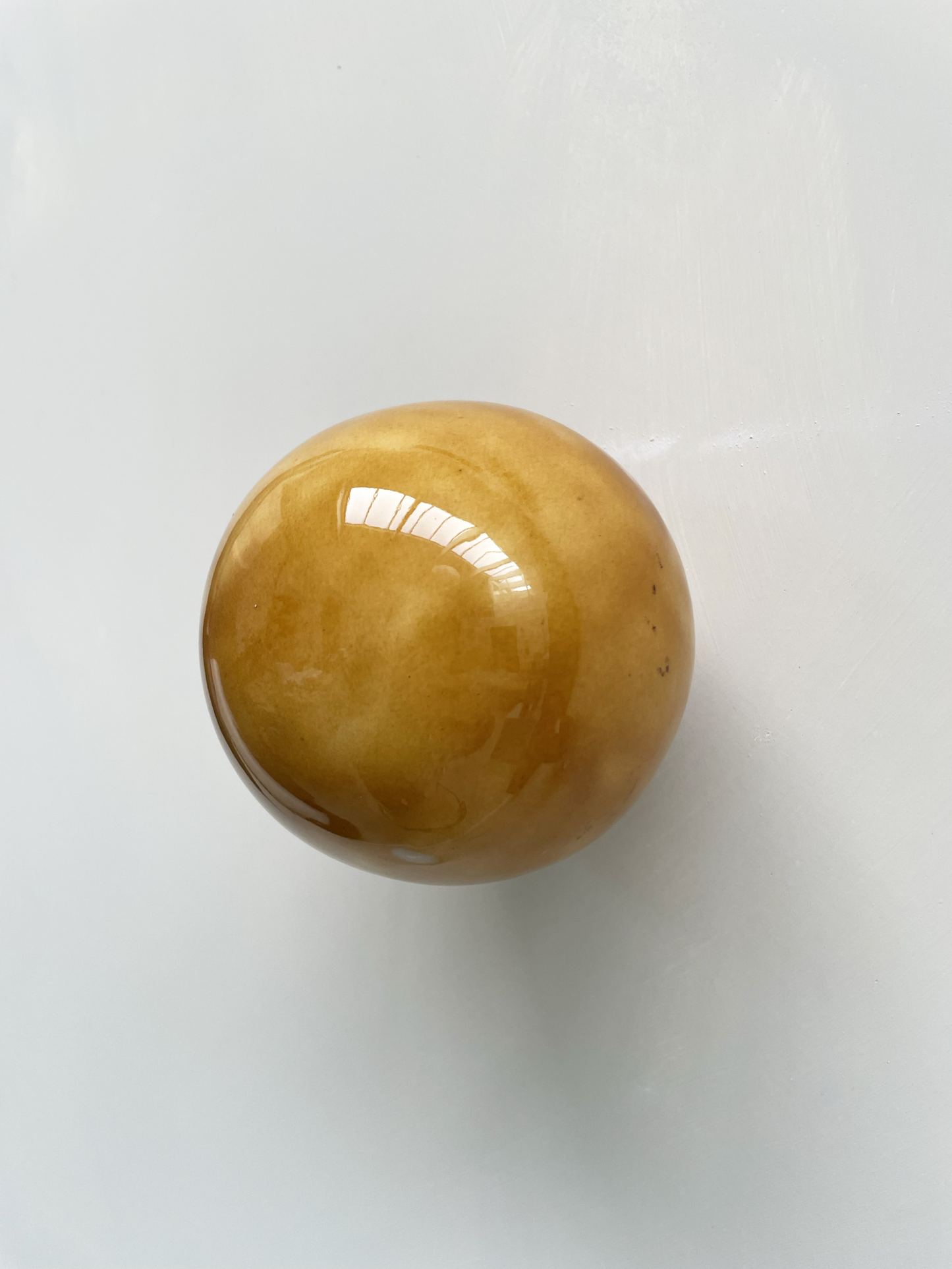 Handcrafted ceramic ball in cognac color, wall sculpture by Edith Beurskens and April van Domburg.