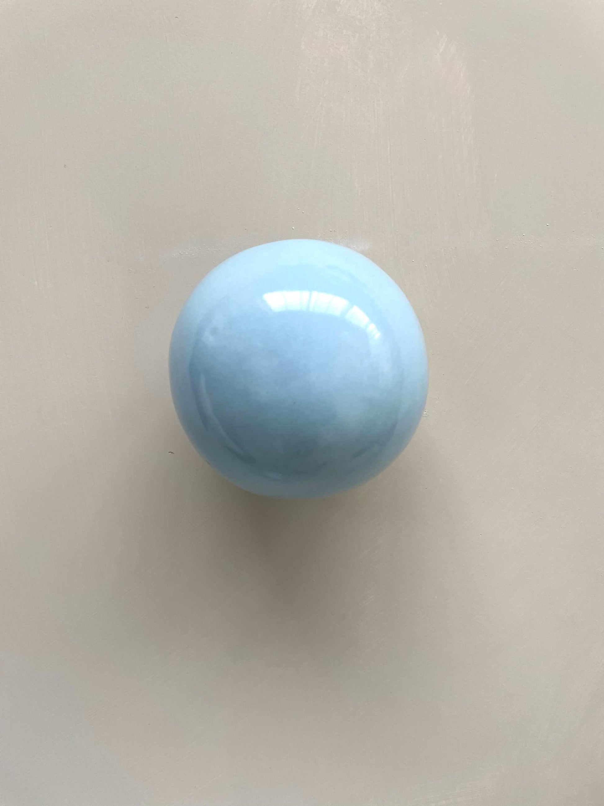 Handcrafted ice blue ceramic ball wall sculpture.
