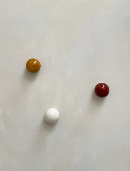 Set of 3 ceramic boules in cognac, rust burgundy, and lace on light background.