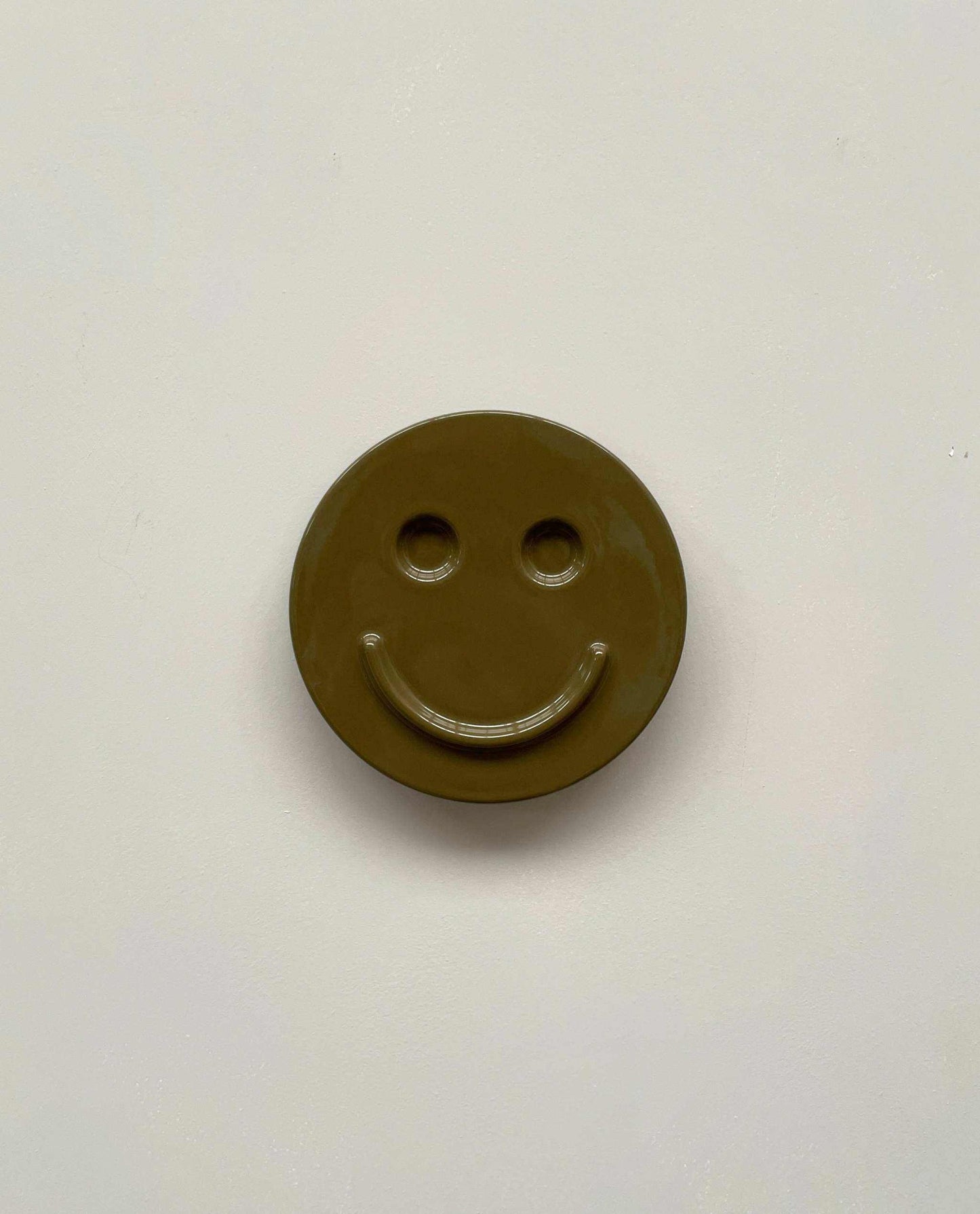 Olive 'HAPPY' ceramic artwork with smiley face, handcrafted by Edith Beurskens.