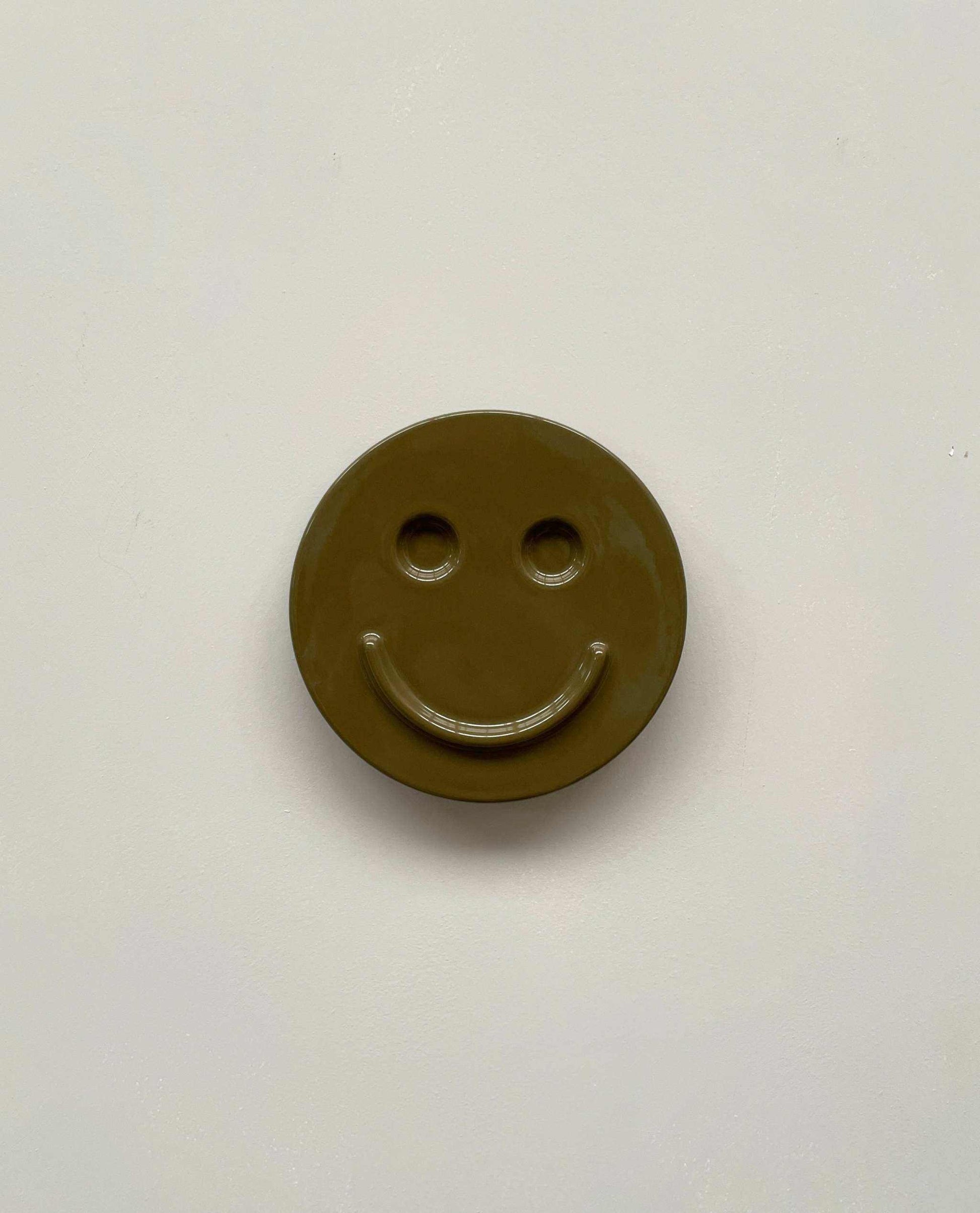 Olive 'HAPPY' ceramic artwork with smiley face, handcrafted by Edith Beurskens.