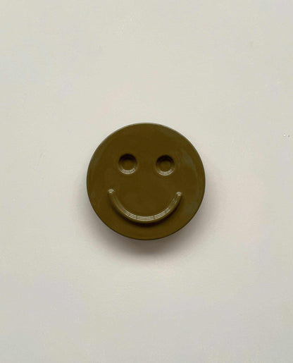 Olive 'HAPPY' ceramic artwork with smiley face, handcrafted by Edith Beurskens.
