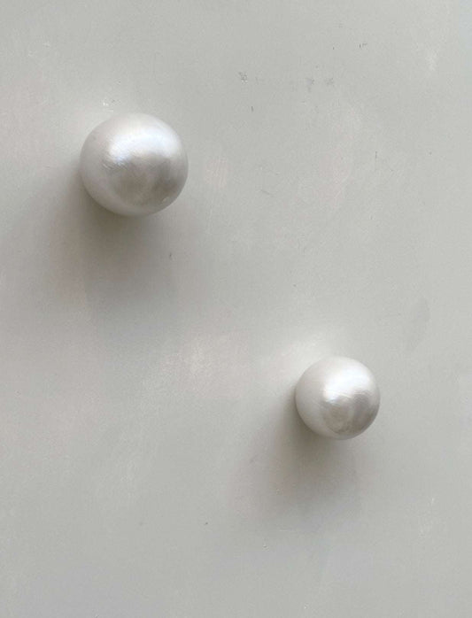 Handcrafted ceramic wall sculpture with pearl-like surface.