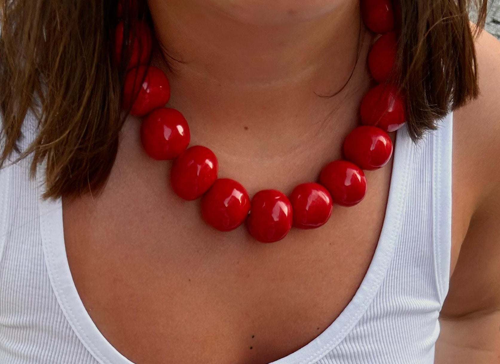 Handmade ceramic bead necklace with large glossy red beads on elastic cord, bold and unique statement jewelry