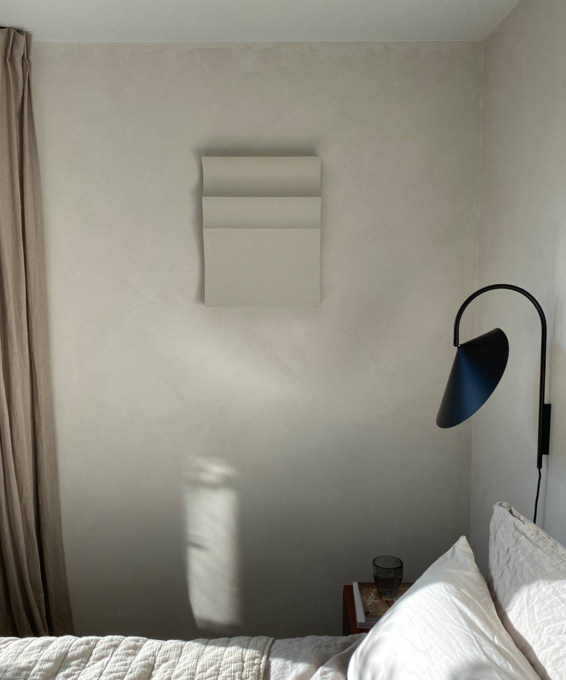 Handmade art piece "#22.01 Ark" on wall, crafted from biodegradable PLA with sand texture and eco-paint, in a minimalist bedroom setting.