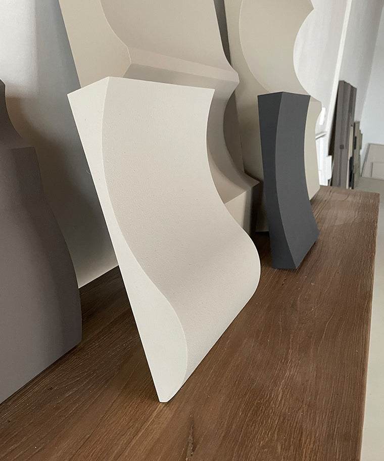 Modern sculptural artwork made of plant-based PLA with sand texture finish displayed on a wooden surface.