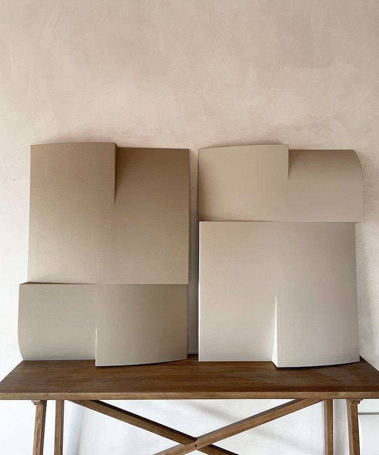 Modern art sculptures made from biodegradable PLA with sand texture and eco-paint, displayed on a wooden table.