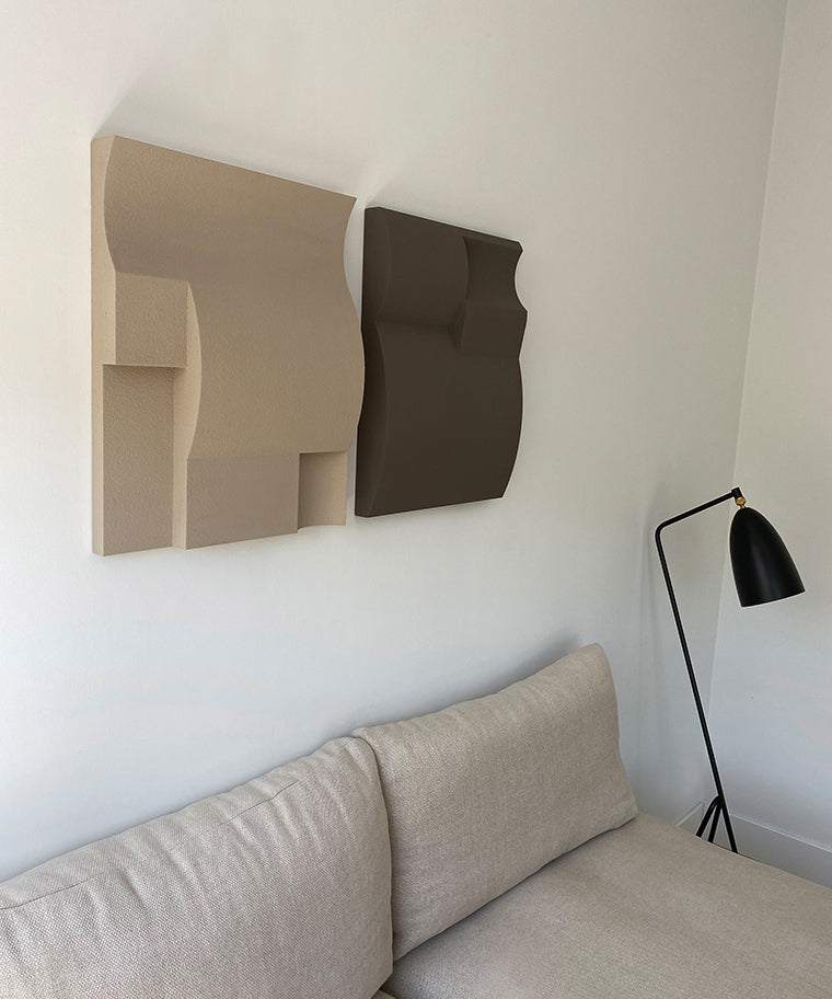 Hand-made abstract wall art in beige and brown tones above a sofa.