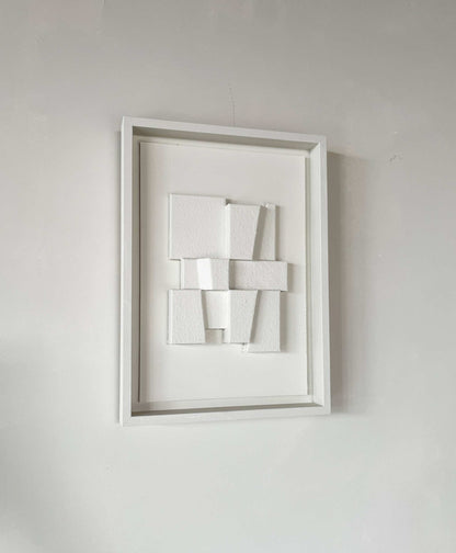 Hand-made 23.2 Deda artwork with textured white geometric design in frame.
