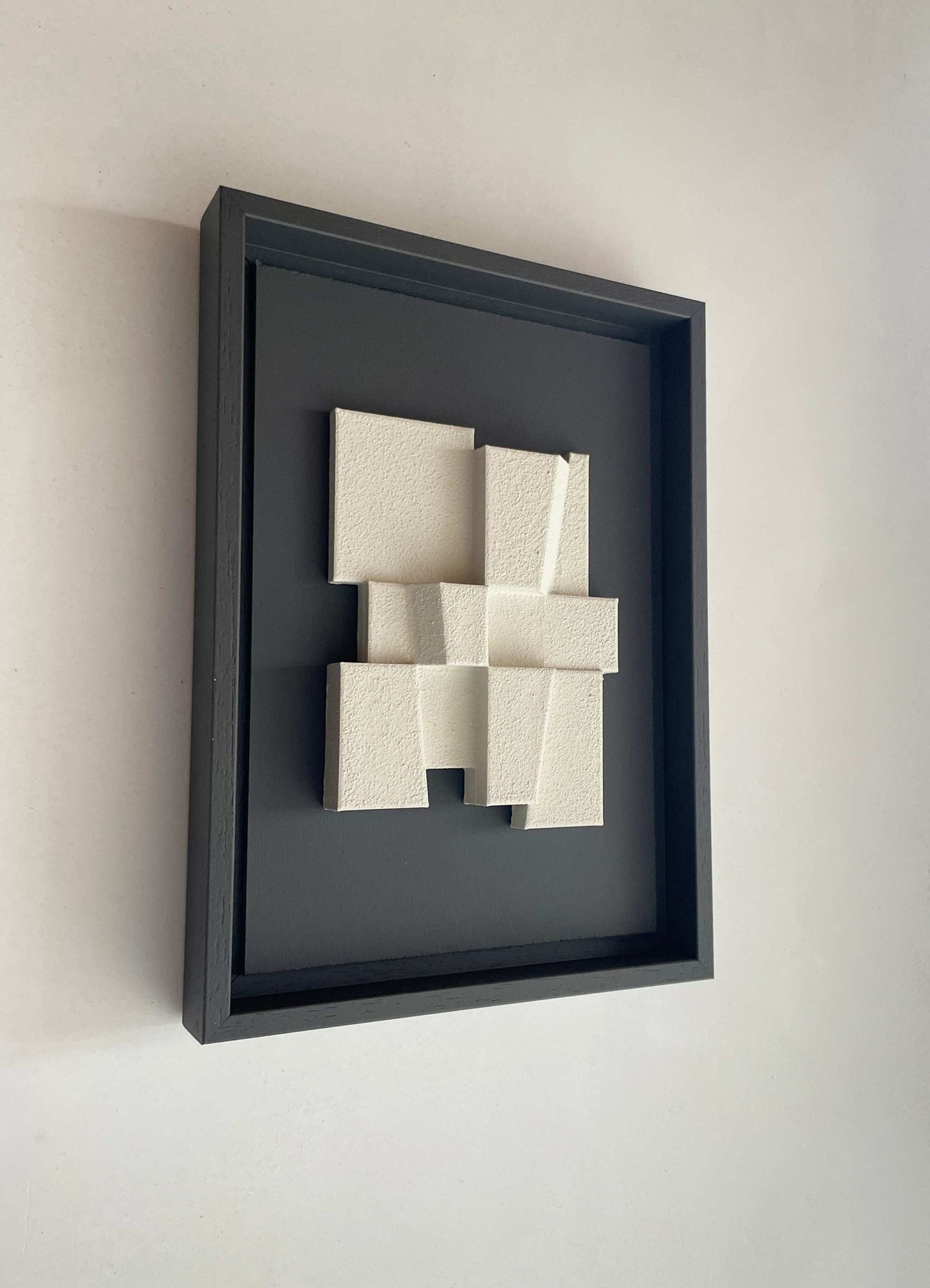 Hand-made 23.2 Deda artwork with textured white design in black frame, made from biodegradable PLA.
