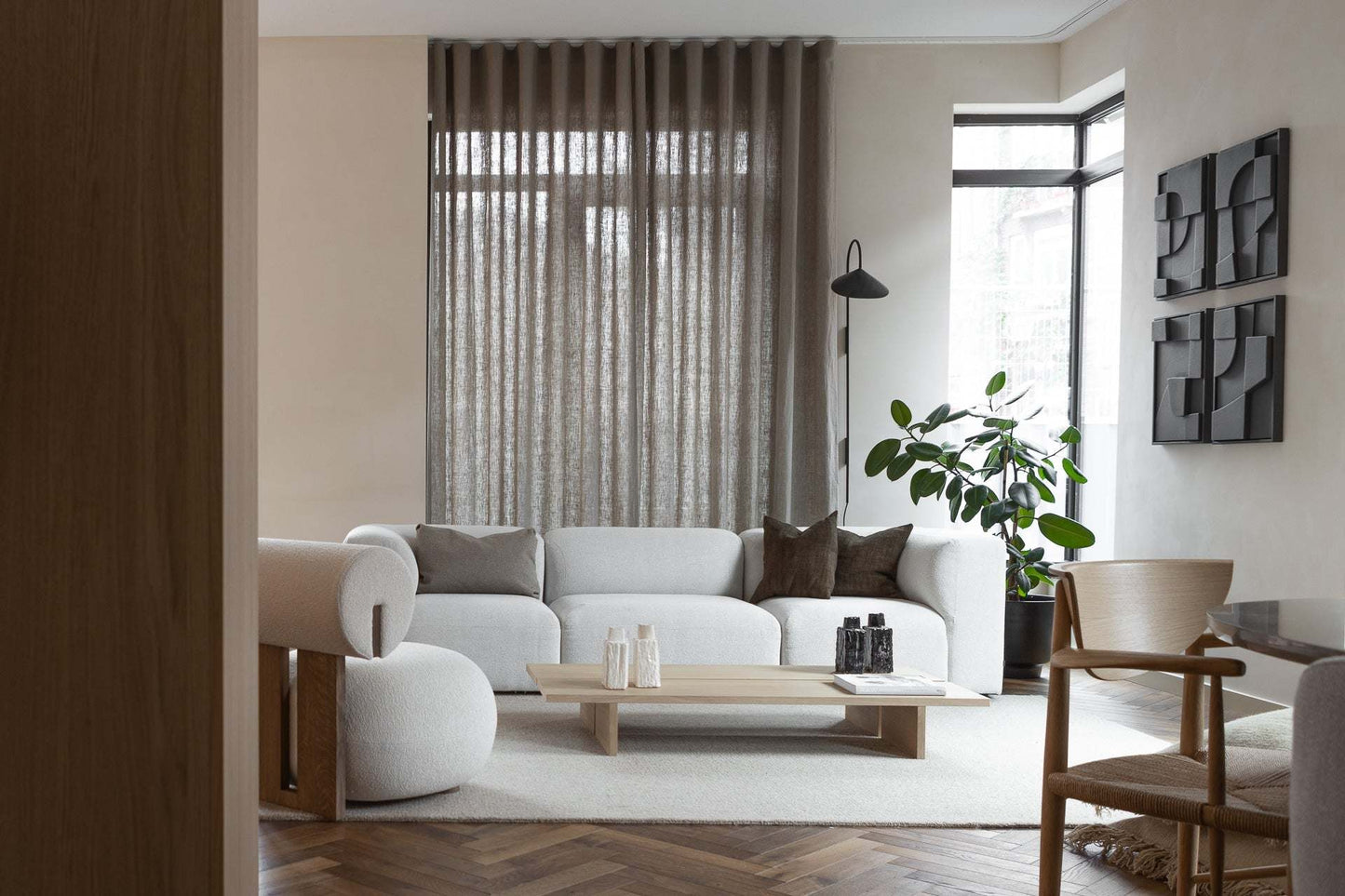 Elegant living room featuring 'Quartet - Tête à Tête' artwork, neutral-toned furniture, and soft lighting.