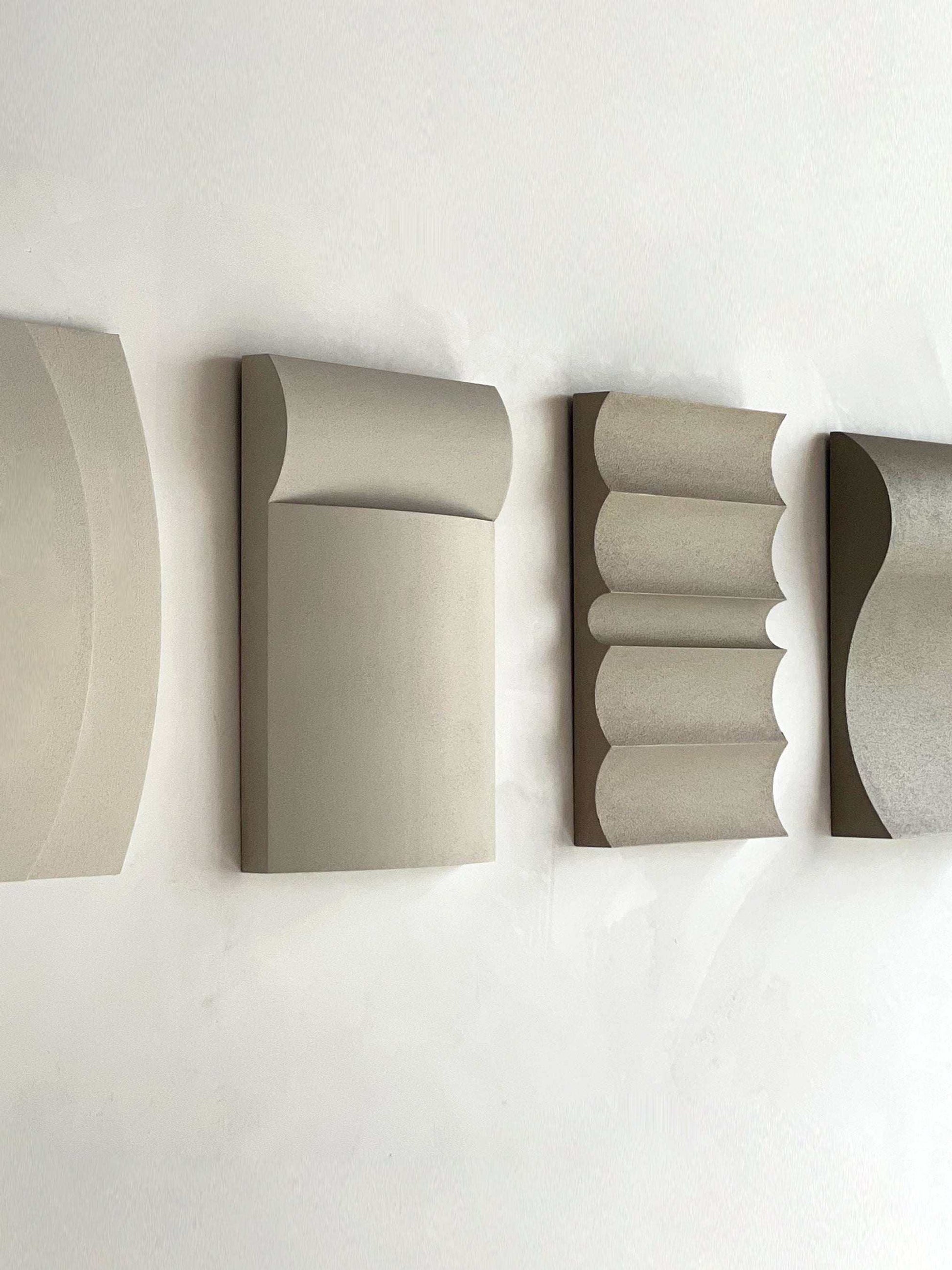 Contemporary wall art in white, shadow white, dark lime, brown wood, and mud grey finishes.